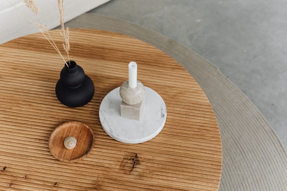 A minimalist wooden coffee table showcasing a vase and marble candle holder for a chic interior design.